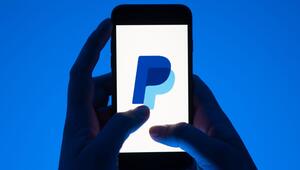 Eine Frau hält ein Smartphone mit dem Paypal Logo