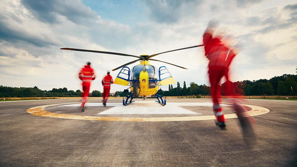 Symbolbild: Rettungssanitäter rennen auf einen Husbchrauber zu