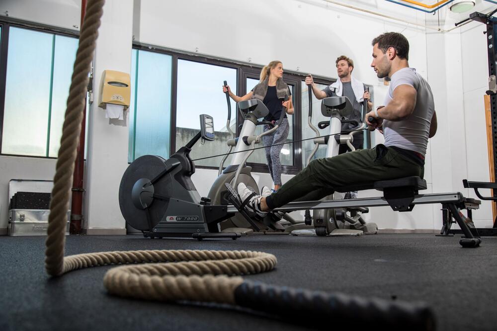 Mann trainiert an einer Rudermaschine im Fitness-Studio