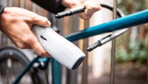 Person schließt ein Fahrrad an einem Zaun an
