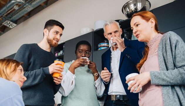 Eine Gruppe Kollegen verbringt ihre Pause in einer Büroküche