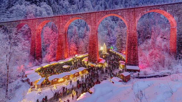 Weihnachtsmarkt in der Ravennaschlucht in der Vogelperspektive. Aquädukt leuchtet rot-pink.
