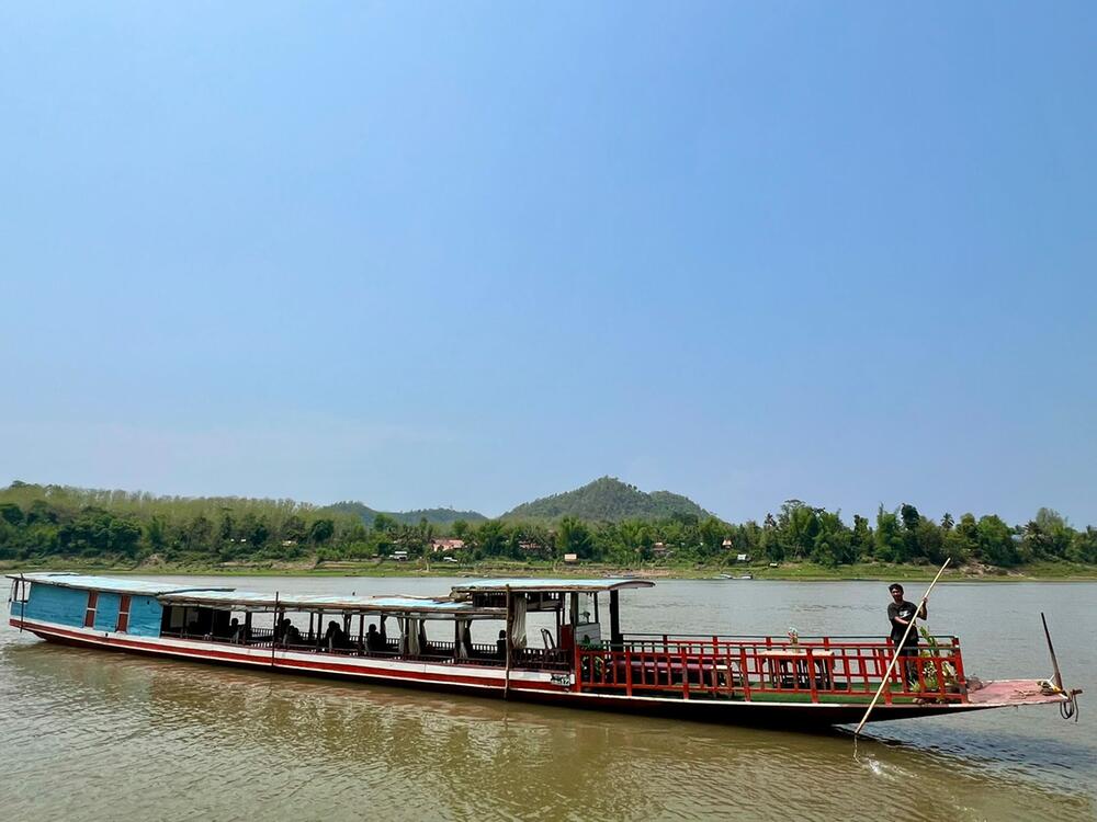 "Slow boat" mit Touristen fährt über den Mekong