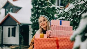 Eine Frau hält einen Weihnachtsgeschenke-Stapel.