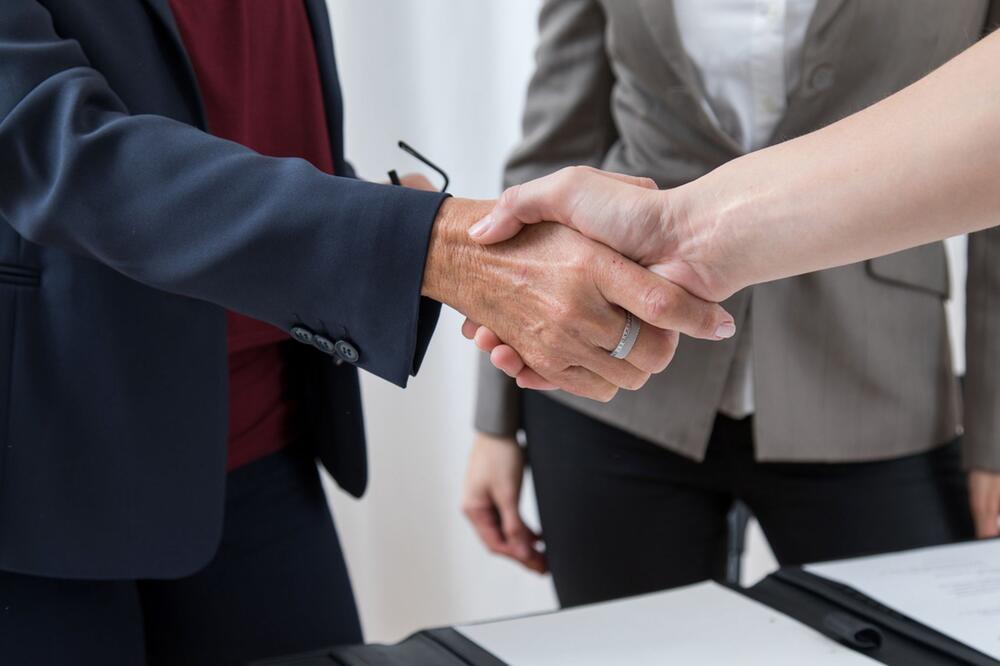 Zwei Frauen reichen sich die Hand