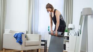 Eine Frau rollt eine Trainingsmatte zusammen