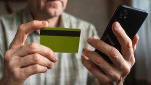Senior mit Smartphone und Kreditkarte in der Hand