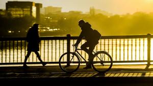 Fahrradfahrer fährt im Sonnenuntergang über eine Brücke