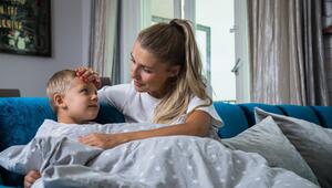 Eine Mutter legt ihre Hand auf die Stirn ihres Sohnes