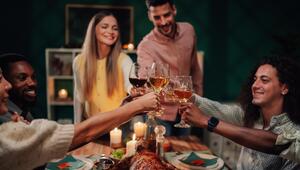 Gruppe Freunde stoßt beim winterlichen Essen mit Wein an