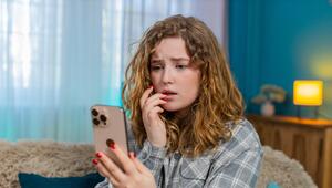 Frau schaut sorgenvoll auf ihr Handy