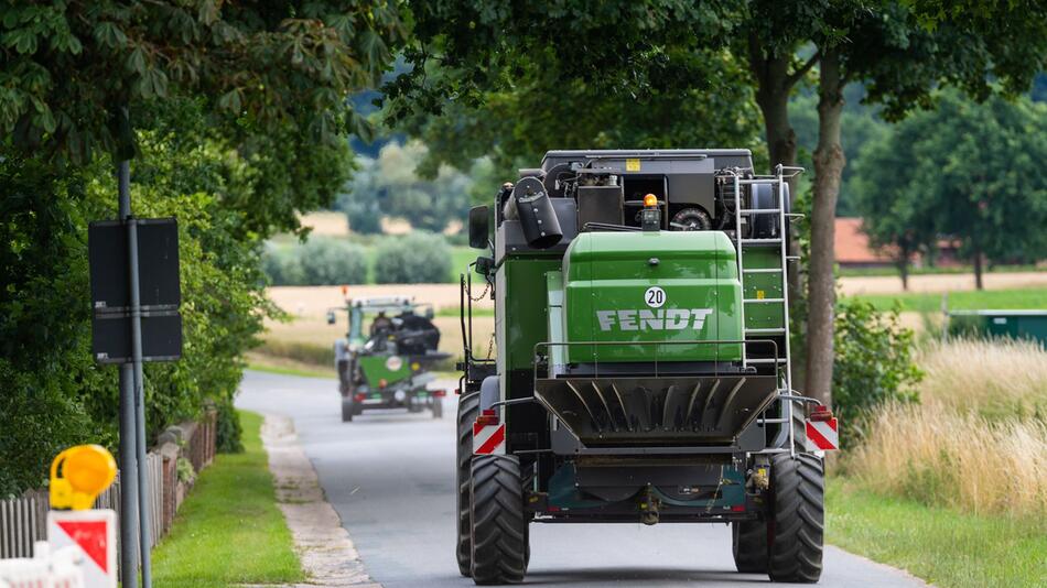 Landwirt fährt mit seinem Mähdrescher auf einer Landstraße