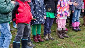 Kinder stehen in einem Garten