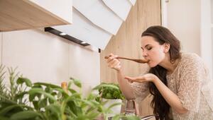 Eine Frau kostet eine Suppe, Käuter im Vordergrund