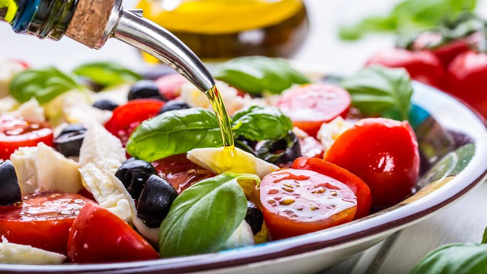 Olivenöl über griechischen Salat geben.