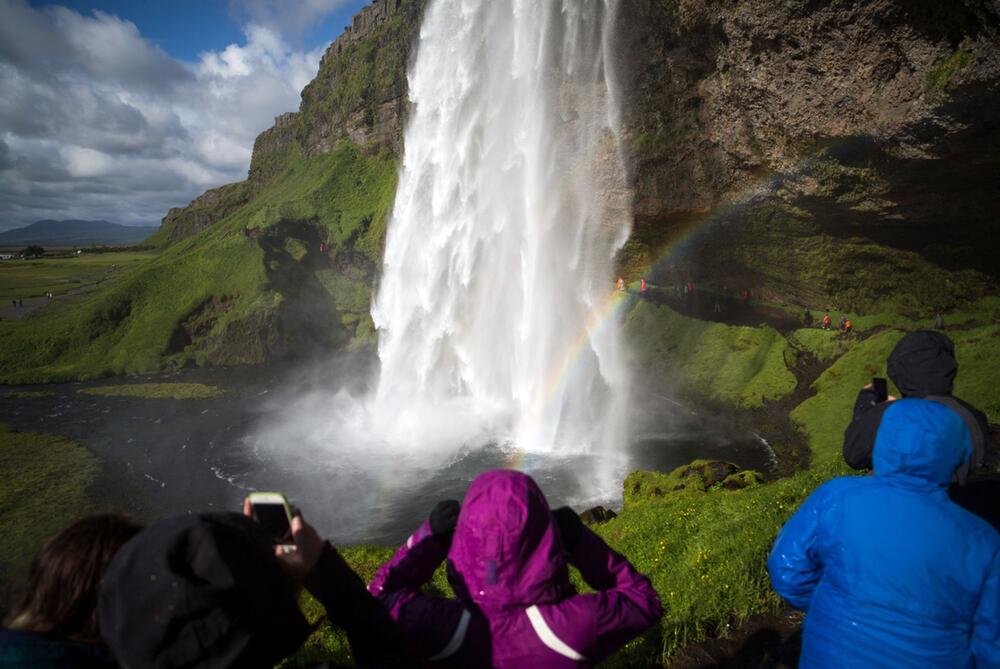 Touristen am Wasserfall Seljalandsfoss