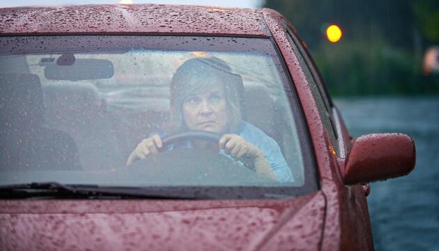 Frau bei gewitter besorgt im Auto