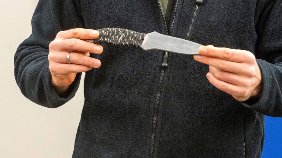 Mann zeigt ein Messer