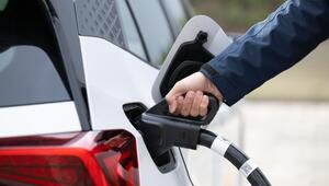 Ein Mann steckt ein Ladekabel in ein Elektroauto