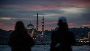 Zwei Menschen blicken auf eine Moschee.