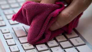 Ein Mann reinigt eine Tastatur mit einem Mikrofasertuch