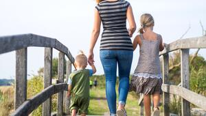 Eine Mutter läuft mit ihren Kindern über einen Steg