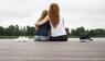 Zwei Frauen sitzen auf einem Steg am See