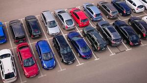 Geparkte Autos in zwei Reihen auf einem Parkplatz.