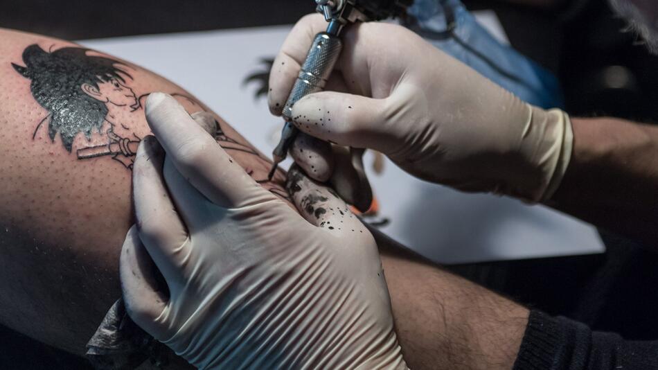 Tätowierer arbeitet an einem Tattoo