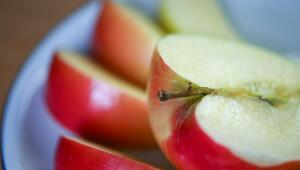 Aufgeschnittener Apfel liegt auf einem Obstteller