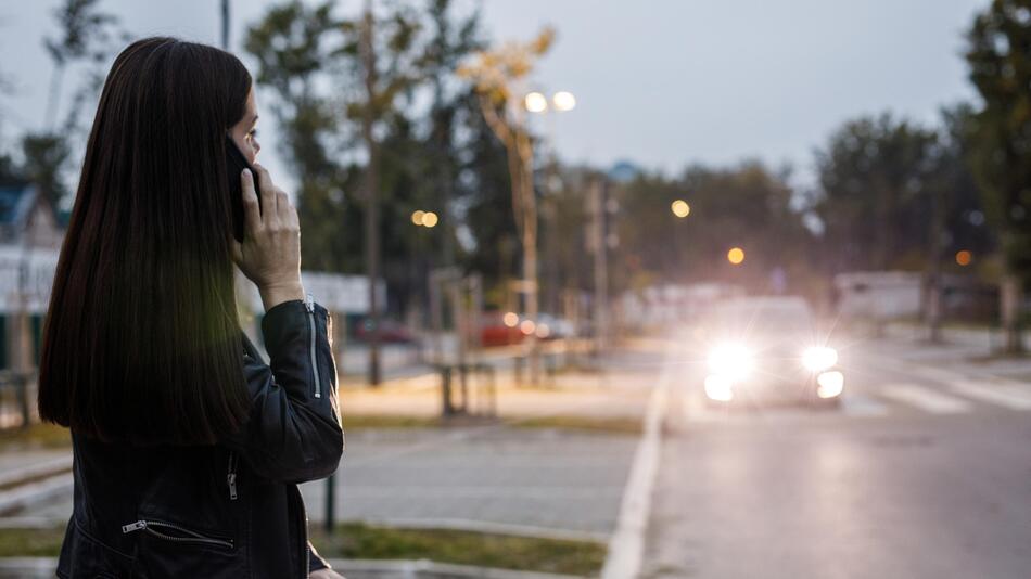 Frau auf Bürgersteig, Auto im Hintergrund