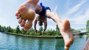 Ein Mann springt ins kühle Nass an einem Kanal