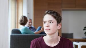 Jugendlicher sitzt genervt in einem Wohnzimmer