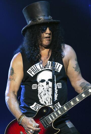 Slash steht mit seiner Gitarre auf der Bühne.