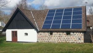 Ein Haus mit einer Fassade aus weißen und steinernen Mauern, braunen Doppeltüren und kleinen ...