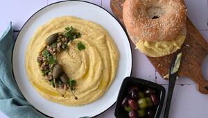 Ein Teller Linsendip, ein Bagel und eine Schale Oliven