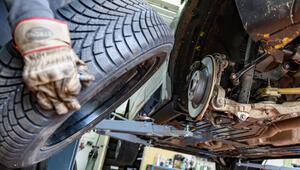 Ein Reifen wird in einer Werkstatt an ein Auto montiert