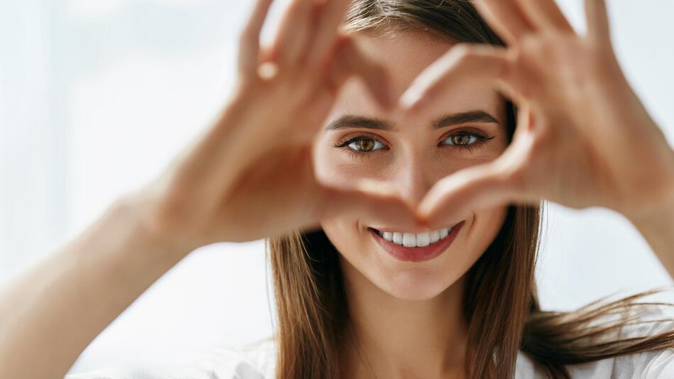 Frau formt Herz mit Fingern