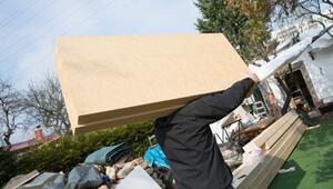 Mann trägt Dämmplatten auf einer Baustelle