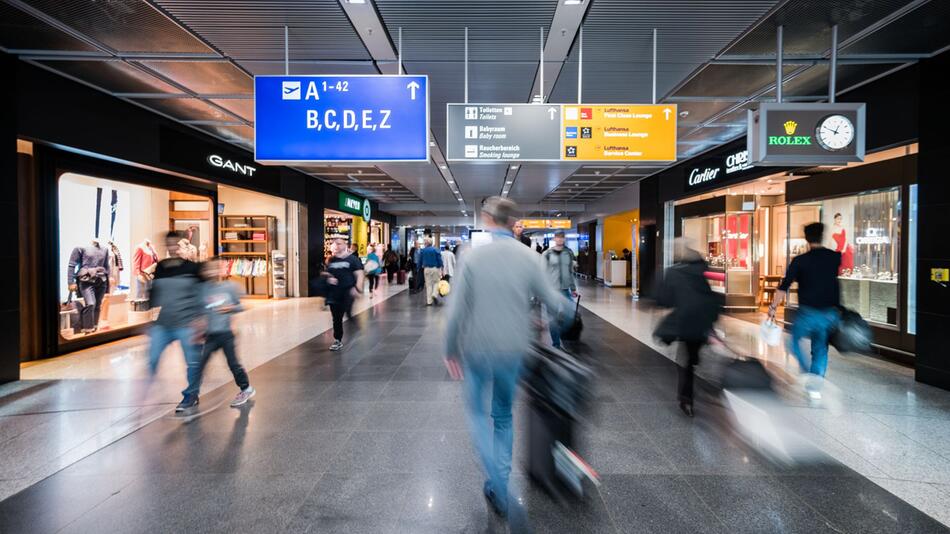 Passagiere gehen durch Transitbereich am Flughafen Frankfurt