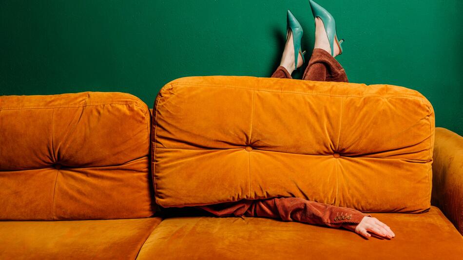 EIne Frau ist teilweise verdeckt von einem Sofa