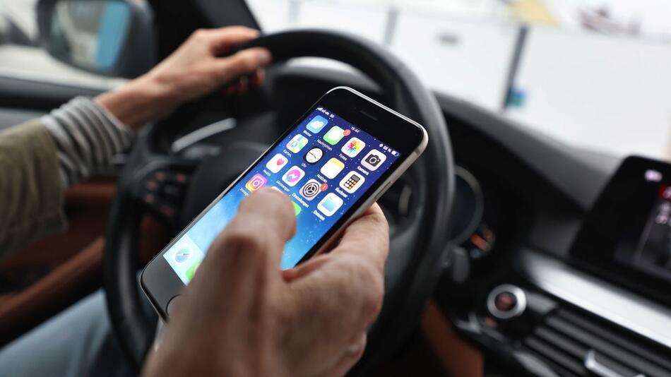 Eine Frau mit Handy am Steuer