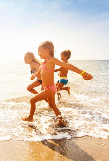 Kinder rennen am Strand