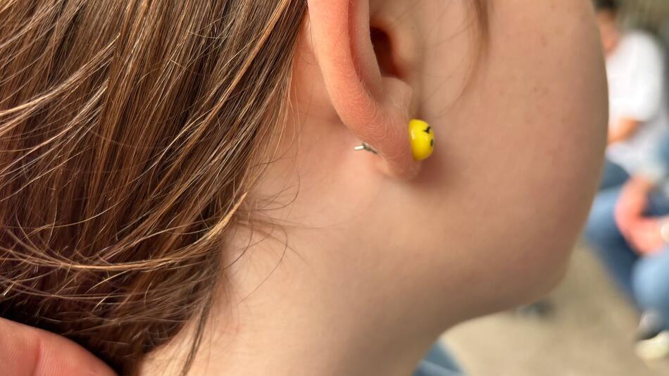 Ein junges Mädchen trägt einen Ohrstecker