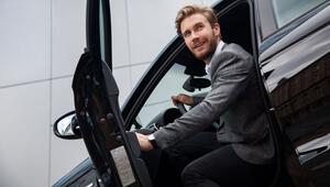 Ein Mann sitzt im Auto bei geöffneter Tür