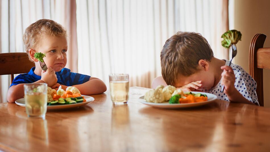 kleine Jungs am Esstisch mögen ihr Gemüse nicht essen