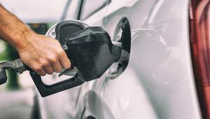 Geöffneter Tankdeckel eines Autos und Hand in Nahaufnahme, die den Wagen betankt