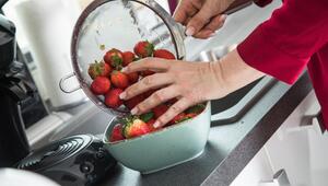 Frau wäscht Erdbeeren