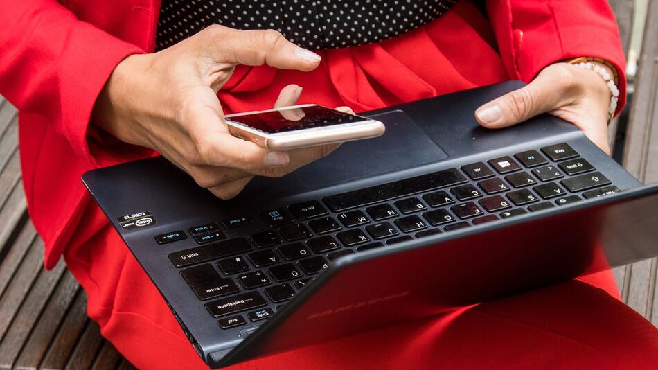 Frau mit Laptop und Smartphone