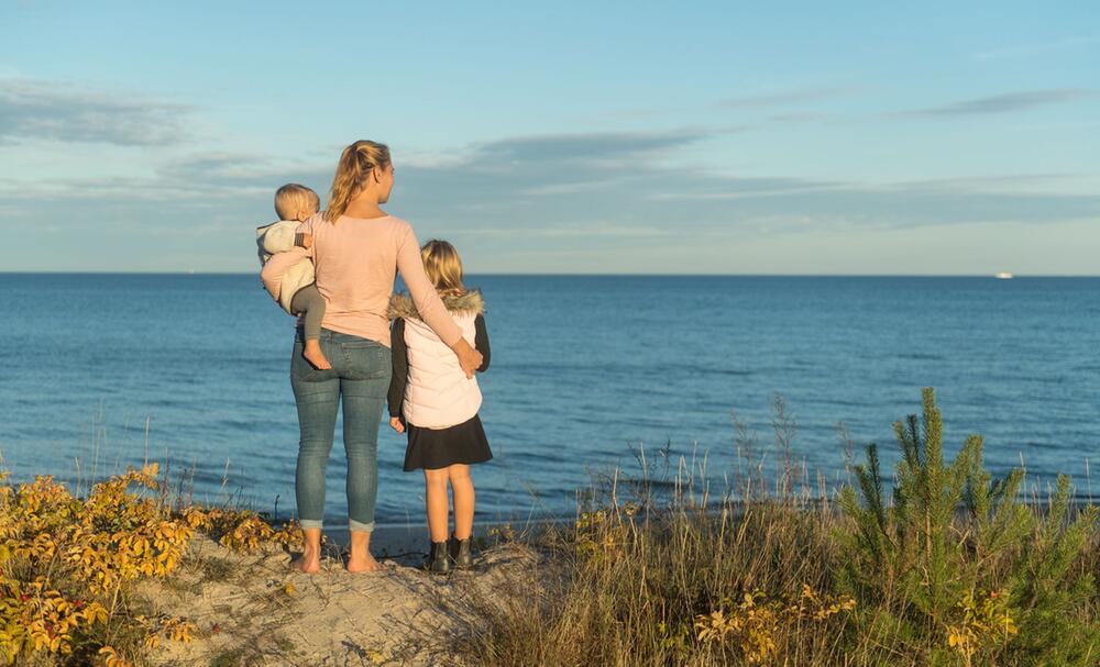 Eine Frau mit ihren Kindern an der Ostsee